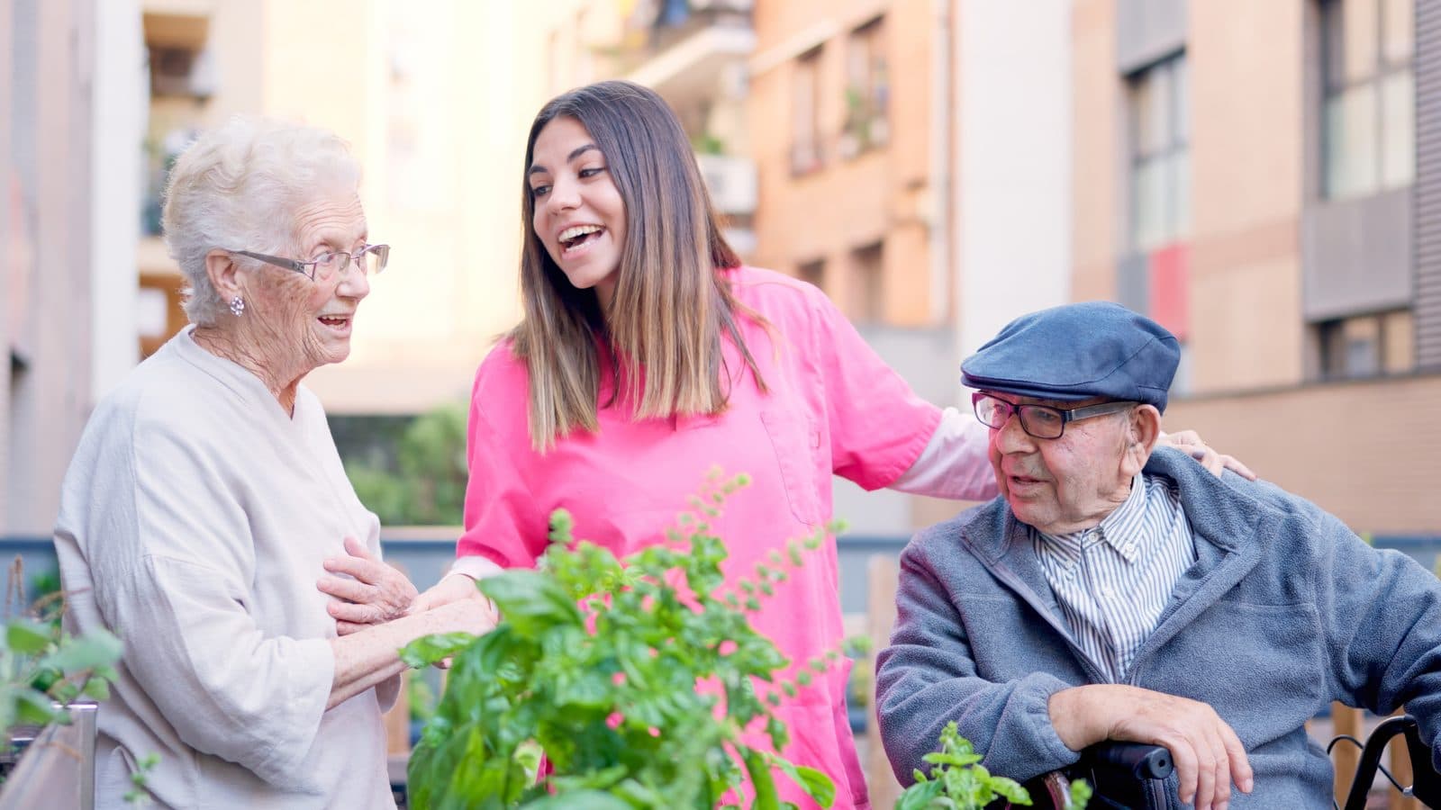Cuidadora conversando con dos personas mayores en el huerto de la terraza
