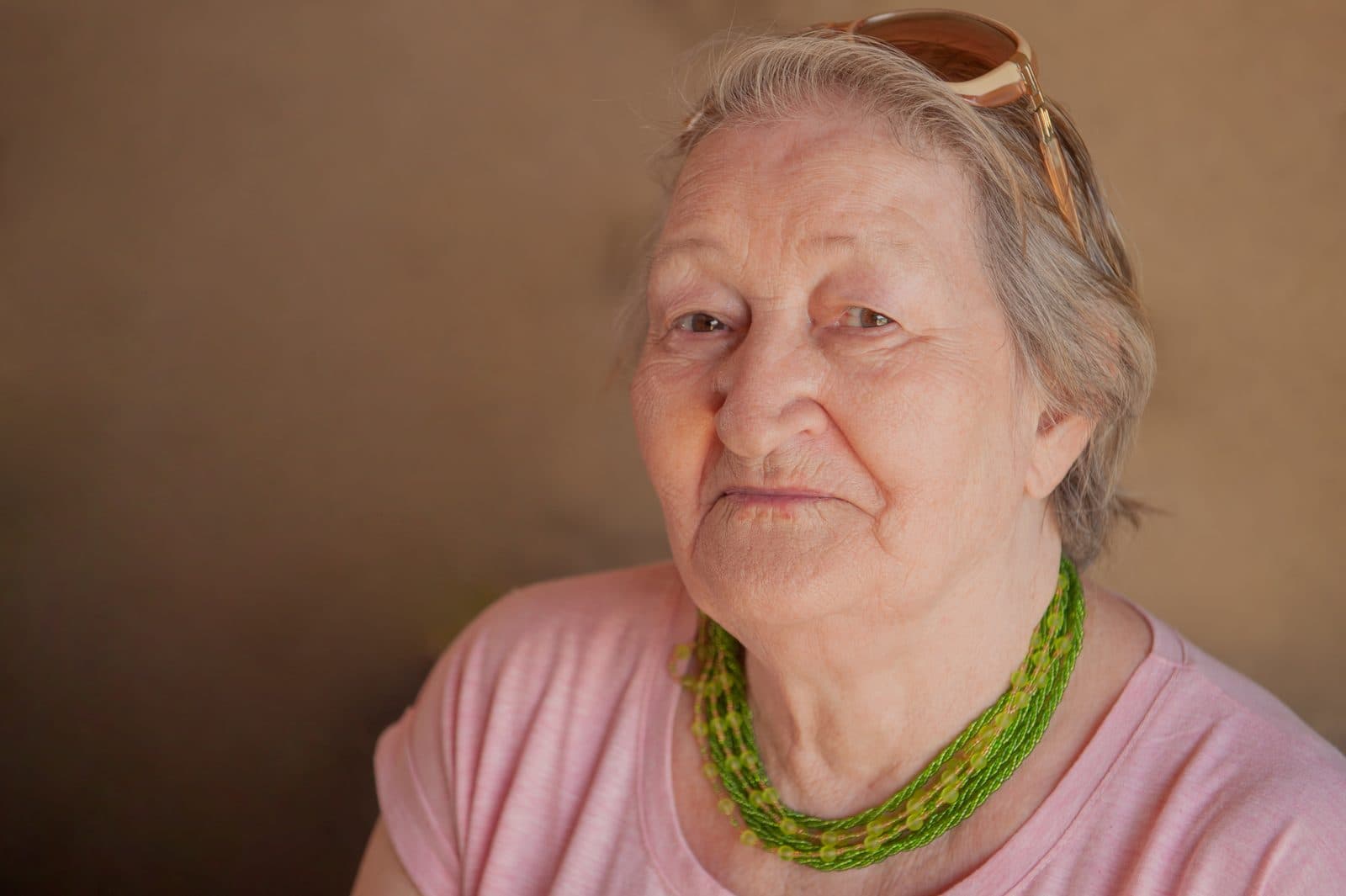 Retrato de una señora mayor con collar de cuentas verdes