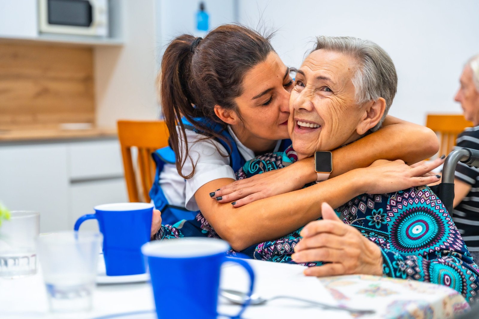 Cuidadora mostrando cariño a una mujer mayor